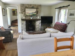 a living room with two white couches and a stone fireplace at Charming modernized country cottage Near Mere, Wiltshire in Mere