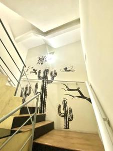 Mural kaktusa na ścianie ze schodami w obiekcie Hotel Casa Blanca w mieście Campina Grande