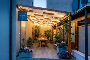 un patio con tavolo, fiori e luci di BOTANIC GUESTHOUSE ESTE a Este