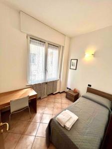 a bedroom with a bed and a desk and a window at Casa Gilda, in centro a Mantova in Mantova