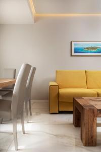 a living room with a yellow couch and a table at Hotel San Teodoro in San Teodoro
