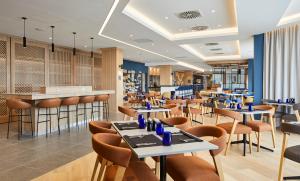 un restaurante con mesas y sillas y un bar en Courtyard by Marriott Stoke on Trent Staffordshire en Newcastle under Lyme