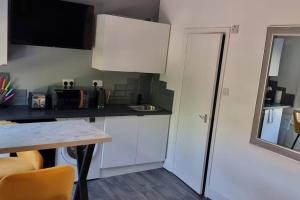 a kitchen with white cabinets and a table at Modern Studio Oasis l 1Bed 1Bath l Central London in London