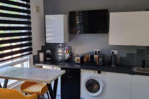 une cuisine avec un lave-linge et une table dans l'établissement Modern Studio Oasis l 1Bed 1Bath l Central London, à Londres