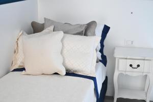 Un dormitorio con una cama con almohadas. en Don Raffaè - Luxury Apartment, en Isquia