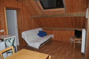 ein Wohnzimmer mit einem Sofa und einem blauen Kissen in der Unterkunft La Source du Broly in Soumagne