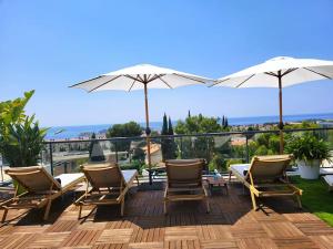 een terras met stoelen en parasols bij Penthouse bandol roof top vue mer in Bandol