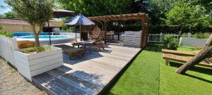 a backyard with a wooden deck and a swimming pool at EMA Cottage in Montjean