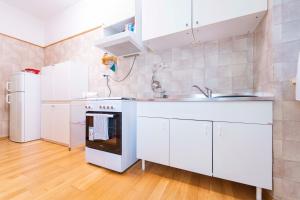 eine Küche mit weißen Schränken, einer Spüle und einem Kühlschrank in der Unterkunft 165 - Casa Garibaldi Centro Chiavari, 400metri dal mare in Chiavari