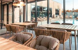 een restaurant met houten tafels en stoelen en een zwembad bij Beach Front Apartment In Lembruch-dmmer See With Kitchen in Lembruch