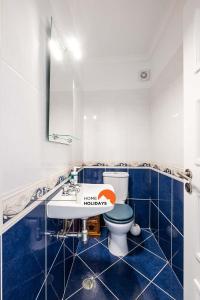 a blue and white bathroom with a toilet and a sink at #082 Fully Equiped with Pool, 450 mts Beach in Albufeira