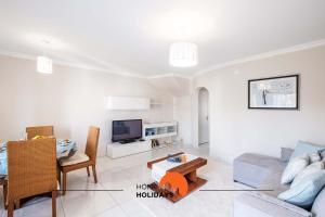 ein Wohnzimmer mit einem Sofa, einem Tisch und einem TV in der Unterkunft #082 Fully Equiped with Pool, 450 mts Beach in Albufeira