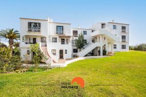 une grande maison blanche avec une pelouse verte dans l'établissement #082 Fully Equiped with Pool, 450 mts Beach, à Albufeira