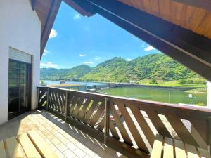 a balcony with a view of a river and mountains at Stilvolle Wellness-Ferienwohnung in Neef Whirlpool, Sauna, Grill, Fitness, Billard & Moselblick in Neef