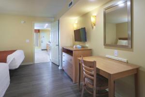 um quarto de hotel com uma mesa e um espelho em Fleur de Lis Beach Motel em Wildwood Crest