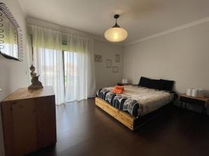 een slaapkamer met een bed en een groot raam bij Moradia praia de Esposende in Marinhas