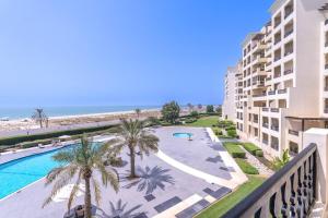 a view of the pool and beach from the balcony of a resort at Studio in Al Hamra Village with Sea View in Ras al Khaimah