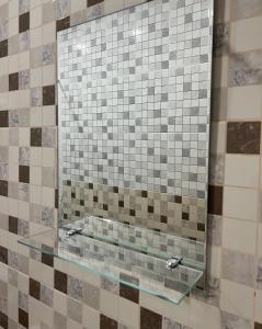 a glass shelf in a shower with a mirror at Olympia in Gudauta