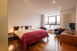 a hotel room with a large bed and a desk at Prümer Gang Restaurant & Hotel in Bad Neuenahr-Ahrweiler