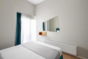 a white bedroom with a bed and a mirror at #FLH - The Wild Lobster, Thessaloniki in Thessaloniki