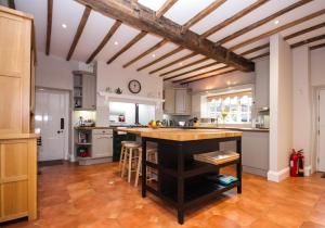 a kitchen with a wooden ceiling and a large island at Greens Norton House in Towcester