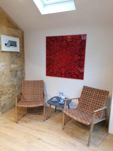 2 Stühle und ein Tisch in einem Zimmer mit einem Gemälde in der Unterkunft Merriman Cottage in Chipping Campden