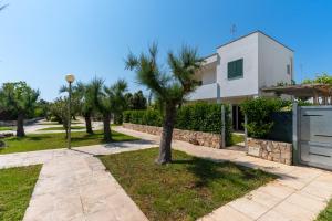 a villa with a palm tree in front of a house at Villa Dalila by BarbarHouse in Torre Inserraglio