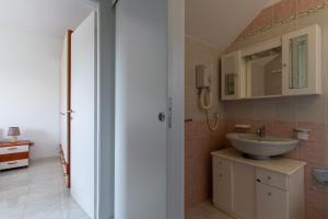 a bathroom with a sink and a mirror at Villa Dalila by BarbarHouse in Torre Inserraglio