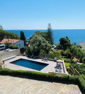 a swimming pool with the ocean in the background at Hotel Cyrnea in Bastia
