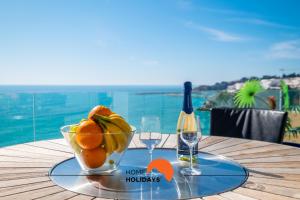 a bowl of fruit on a table with a bottle of wine at #041 Private Beach View, High Speed WiFi, 20 mts Beach in Albufeira