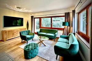 uma sala de estar com mobiliário verde e uma televisão em DOLCEVILLA - Exklusiver Familienurlaub im Meraner Land em Vollan