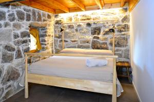 1 dormitorio con 1 cama en una pared de piedra en NIMA Navacerrada, en Navacerrada