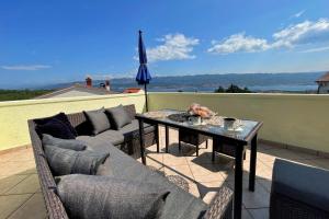 une terrasse avec un canapé, une table et un parasol dans l'établissement Top Apartments, à Šilo