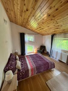 a bedroom with a large bed with a wooden ceiling at Rooms Ljubenko in Karlovac
