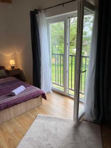 a bedroom with a bed and a sliding glass door at Rooms Ljubenko in Karlovac