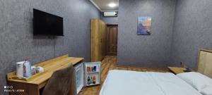 Cette chambre comprend un lit et une télévision murale. dans l'établissement Very Well Guest House, à Baku