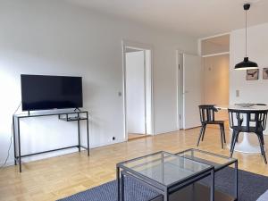 a living room with a flat screen tv and a table at Apartment In Valby in Copenhagen