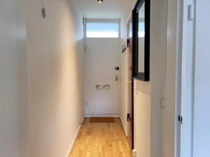 a hallway with a white door and a wooden floor at Apartment In Valby in Copenhagen