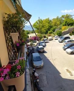 a view of a street with parked cars and flowers at Xenofon's cozy apartment in Corfu