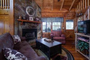 sala de estar con sofá y chimenea en Mountain Time Cabin, Hot tub, Fire Pit, Fireplace, en Blue Ridge