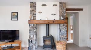 a living room with a fireplace and a tv at Newlands in Rusland