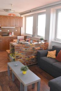 a living room with a couch and a brick wall at Panorama View Family Apartment in Veszprém