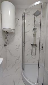 a bathroom with a shower with a glass door at Луксозен апартамент с две спални in Burgas