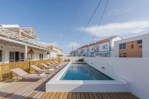 - une piscine avec des chaises longues sur une terrasse en bois dans l'établissement Villa da Comporta - Apartamento T3, à Comporta