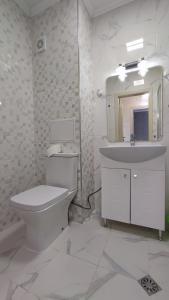 Baño blanco con aseo y lavamanos en Луксозен апартамент с две спални en Burgas
