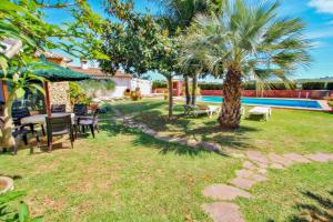 a garden with a table and chairs and a swimming pool at Finca La Coma - modern, well-equipped villa with private pool in Benissa in Benissa
