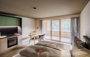 a bedroom with a bed and a television and a desk at freiraum Apartments in Mellau