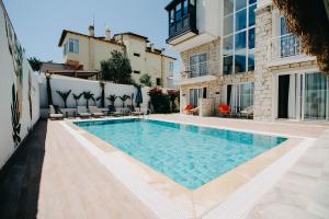 a swimming pool in front of a building at L'ETRO MAISON ALACATI HOTEL in Çeşme