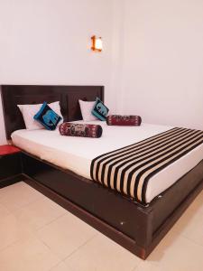 una cama con almohadas en una habitación en Heritage Rangiri Villa en Dambulla