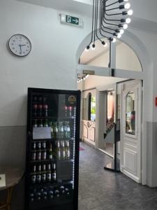 a room with a refrigerator filled with bottles and a clock at Hotel Lübecker Hof in Lüneburg
